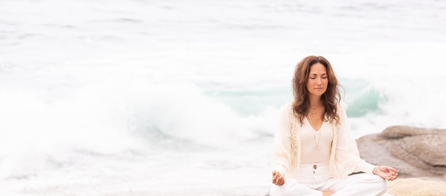 Seated in meditation on the rocks by the ocean