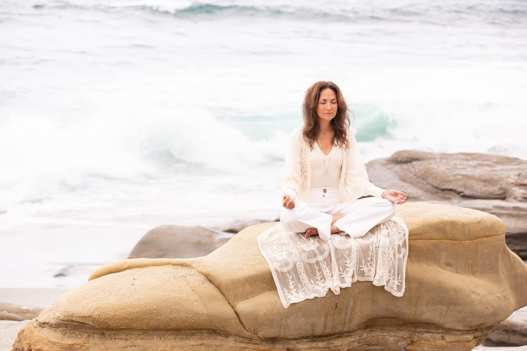 Seated in meditation on the rocks by the ocean